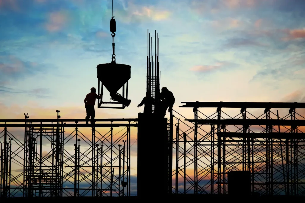 Obreros trabajando es una estructura de andamiaje con grúa al aterdecer