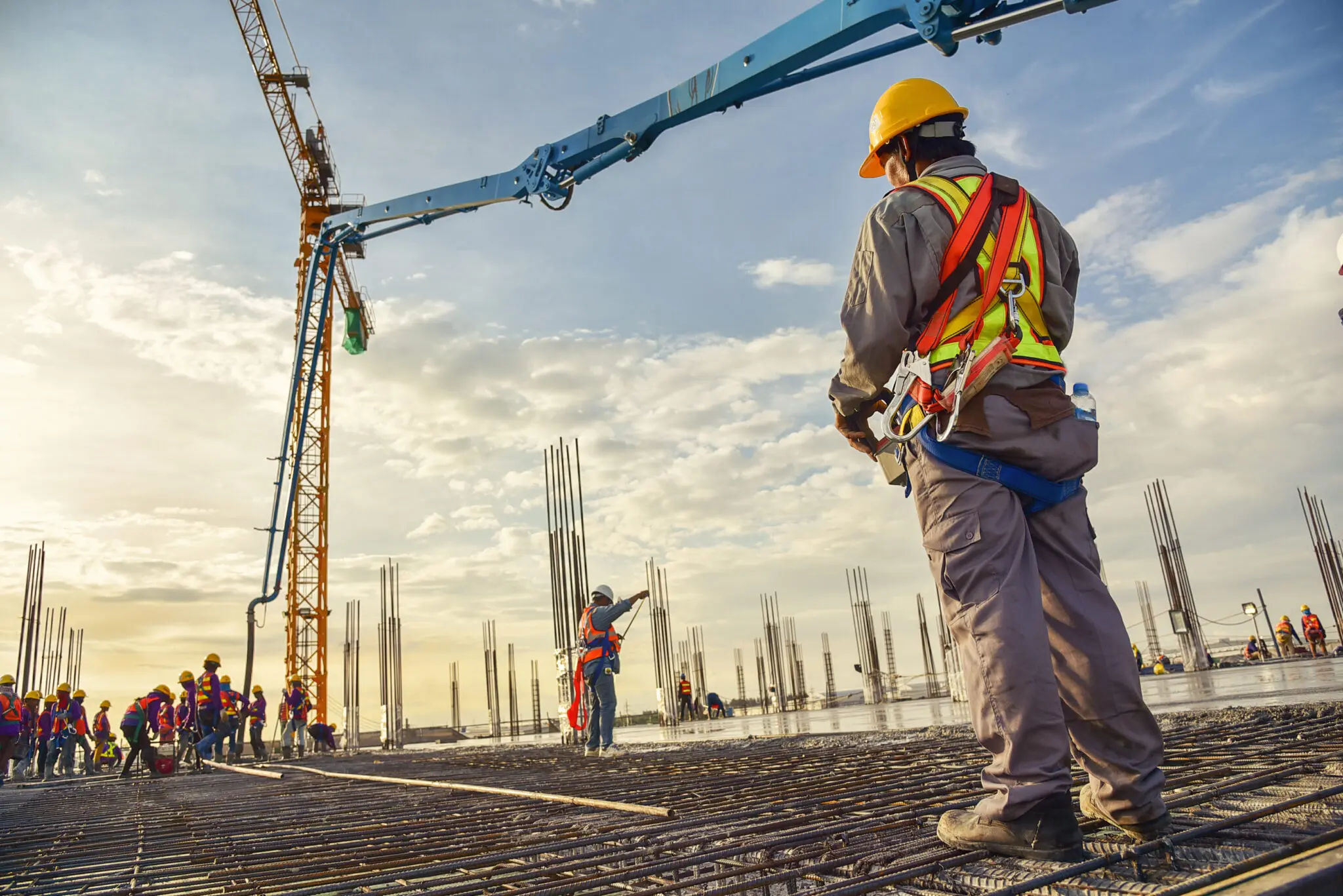 Obrero trabajando en una losa de cimentación con barras de acero en un proyecto de construcción